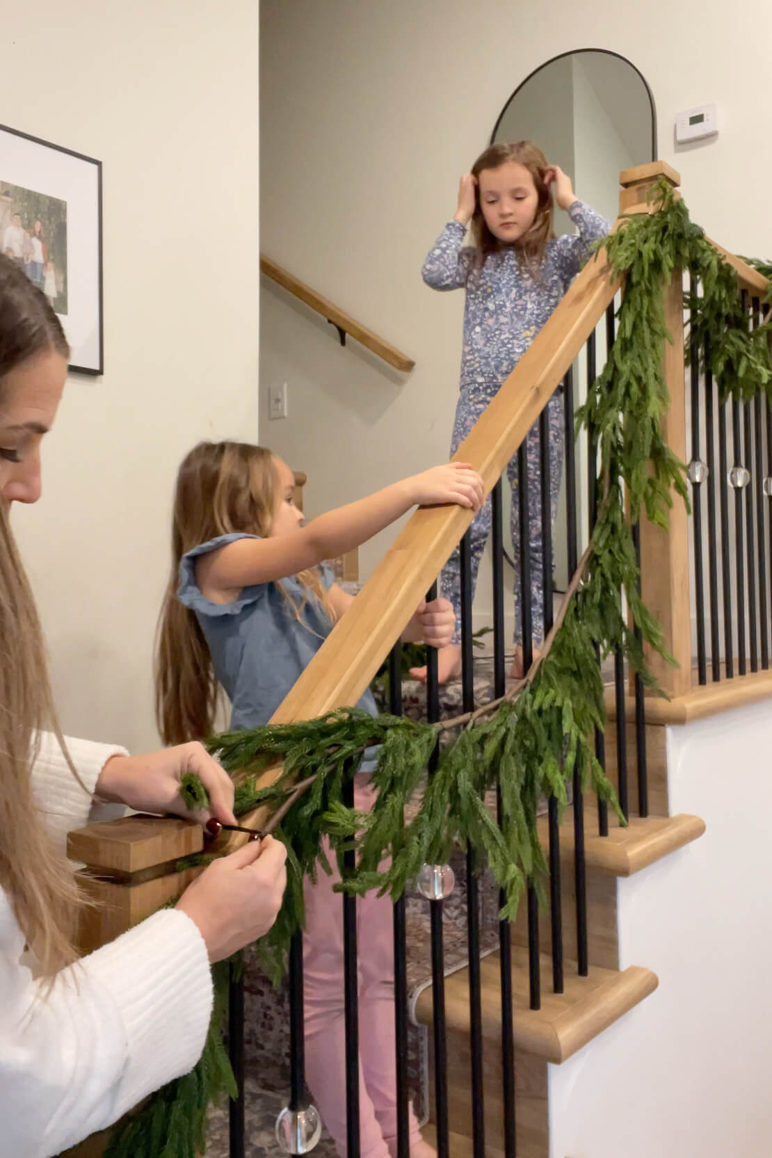 Hanging Christmas garland on a staircase.